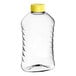 A clear ribbed PET honey bottle with a yellow cap.