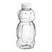 A clear plastic Bear PET honey bottle with a white plastic flip top lid.