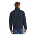 A man wearing a navy CornerStone work jacket.
