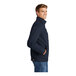 A person wearing a navy CornerStone work jacket with a zipper.