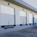 An Illinois Engineered Products heavy-duty steel folding security gate installed in front of storage unit doors.