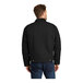 A man wearing a black CornerStone work jacket with two pockets.