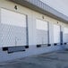A row of Illinois Engineered Products galvanized steel folding security gates in front of storage units.