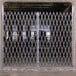 An Illinois Engineered Products heavy-duty galvanized steel folding double security gate with a diamond pattern.