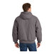 A man wearing a CornerStone metal grey hooded work jacket.