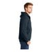 A person wearing a navy CornerStone heavy weight thermal lined hooded sweatshirt.