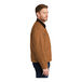 A man wearing a CornerStone brown work jacket with a black corduroy collar.