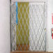 An Illinois Engineered Products heavy-duty galvanized steel folding security gate securing a door.