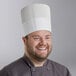 A man wearing a white Choice disposable chef hat.