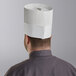 A man wearing a white Choice disposable chef hat.