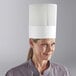 A woman wearing a white Choice disposable chef hat.