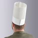 A man wearing a white Choice disposable chef hat.