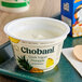 A white Chobani yogurt container with a blurry green and white label.