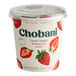 A plastic container of Chobani Non-Fat Strawberry Greek Yogurt with strawberries on it.