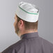 A man wearing a green and white Choice adjustable disposable overseas cap.