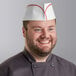 A man wearing a red striped Choice disposable chef hat.