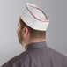 A man wearing a red striped Choice adjustable disposable overseas cap.