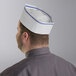 A man wearing a blue striped Choice adjustable disposable overseas cap.