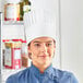 A woman wearing a fully formed white pleated Choice chef hat.