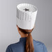 A woman wearing a white pleated Choice chef hat.