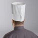 A man wearing a white Choice pleated chef hat.