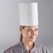 A woman wearing a white Choice disposable chef hat.