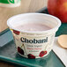 A white container of Chobani Non-Fat Black Cherry Greek Yogurt with a black cherry on it.