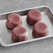 A tray of red Blender Bites Power Berry frozen smoothie pucks.
