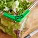 A Choice stainless steel food pan corner label with a green blank write-on label in a salad container.