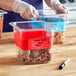 A hand labels a Choice Red stainless steel food pan with a white marker.