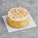 Abe's Vegan vanilla-frosted layer cake with sprinkles on top.
