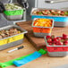 A metal container with 1/2 and 1/3 size stainless steel food pans with write-on bands.