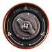 A close up of a metal button with a black and white design on a circular object.