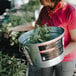 A woman holding a Behrens galvanized steel tub of plants.