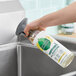 A hand holding a bottle of Seventh Generation Lemon Chamomile All-Purpose Cleaner.