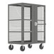 A grey Valley Craft security cart with shelves and a metal cage door on wheels.