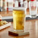 A drum of Endless Harvest apple fruit puree on a table with a glass of beer.