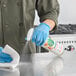 A person in a blue uniform spraying Seventh Generation Fresh Morning Meadow All-Purpose Cleaner on a counter.