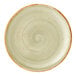 A round, green ceramic coupe plate with a subtle swirl pattern and a slightly rustic, brown-edged rim.