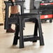 A man holding a Stanley black plastic folding sawhorse.