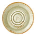A green ceramic saucer with a rustic, speckled finish and concentric circular ridges.