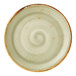A round, green ceramic coupe plate with a subtle swirl pattern and a brown rim.