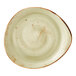 A large, irregularly shaped green ceramic plate with a speckled finish and rustic edges.