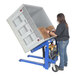 A woman using a Vestil pallet tilter to lift a box.