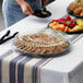 A Visions black plastic catering tray with cookies and fruit on a table.