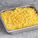 A metal pan of Papetti's fully cooked scrambled eggs with yellow food inside.