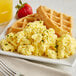 A plate of waffles and Papetti's Traditional Scrambled Eggs with strawberries.