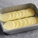 A baking pan filled with Papetti's round scrambled egg patties on a counter in a school kitchen.