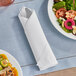 A table with a plate of food and Tork LinStyle white dinner napkin.