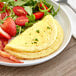 A white plate with a Papetti's Egg Omelet and salad.